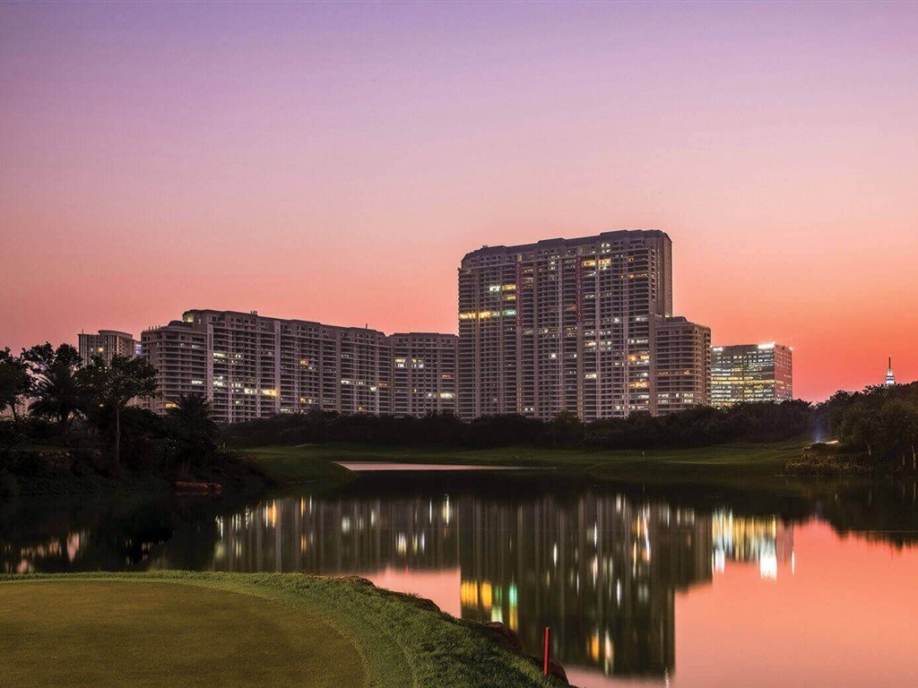 DLF The Camellias towers at sunset seen across the golf course lake