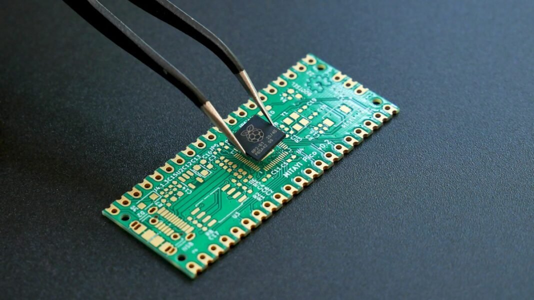 Tweezers placing a small microchip onto a green circuit board
