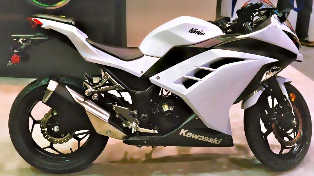 A white Kawasaki Ninja 300 sports motorcycle at a motorcycle show