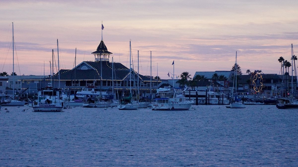 The Balboa Pavilion and boats in Newport Harbor at dusk